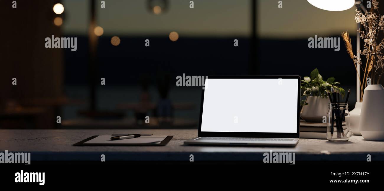 A modern dark office at night featuring a white-screen laptop computer ...