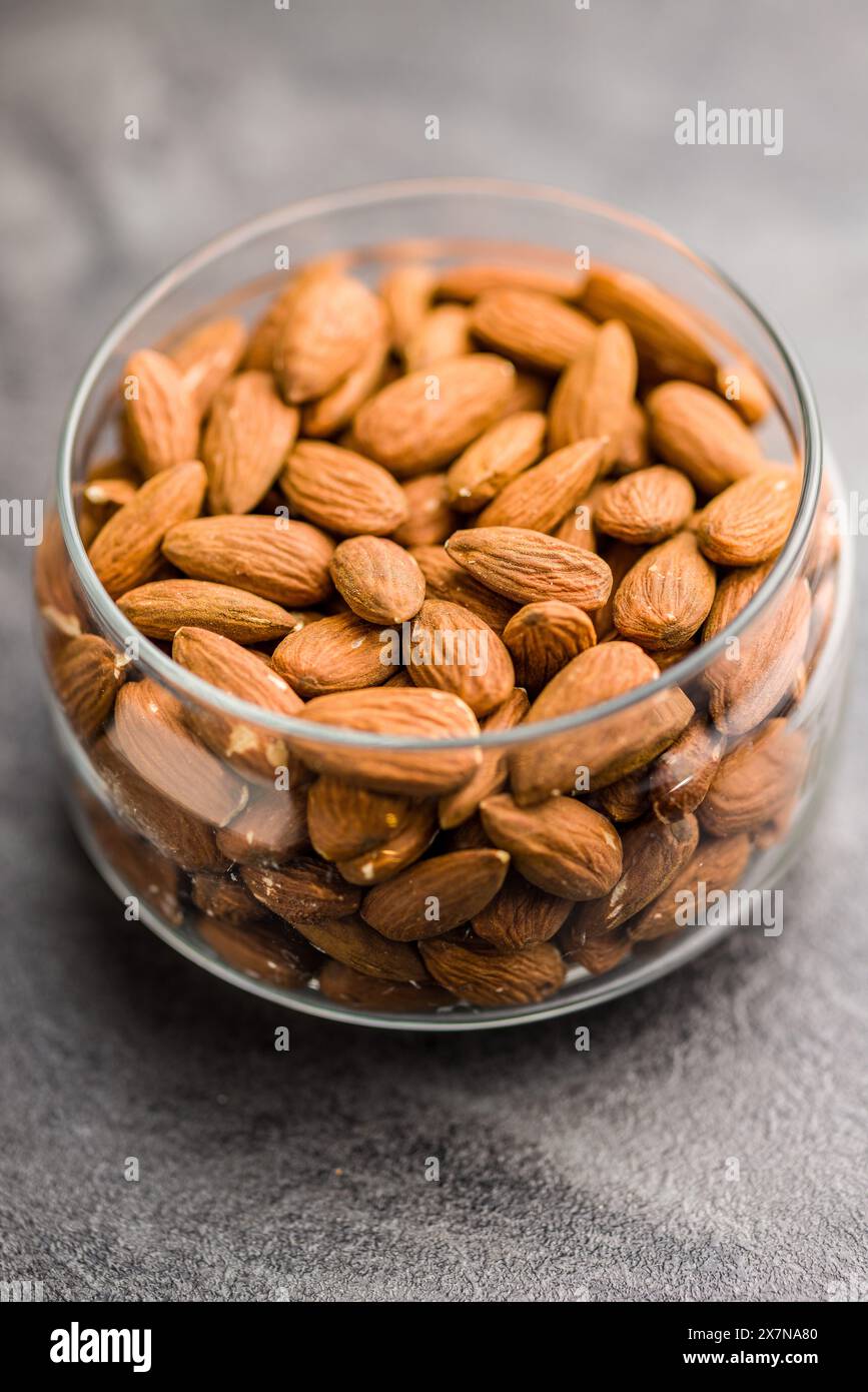 Peeled almond nuts in jar on a kitchen table. Stock Photo
