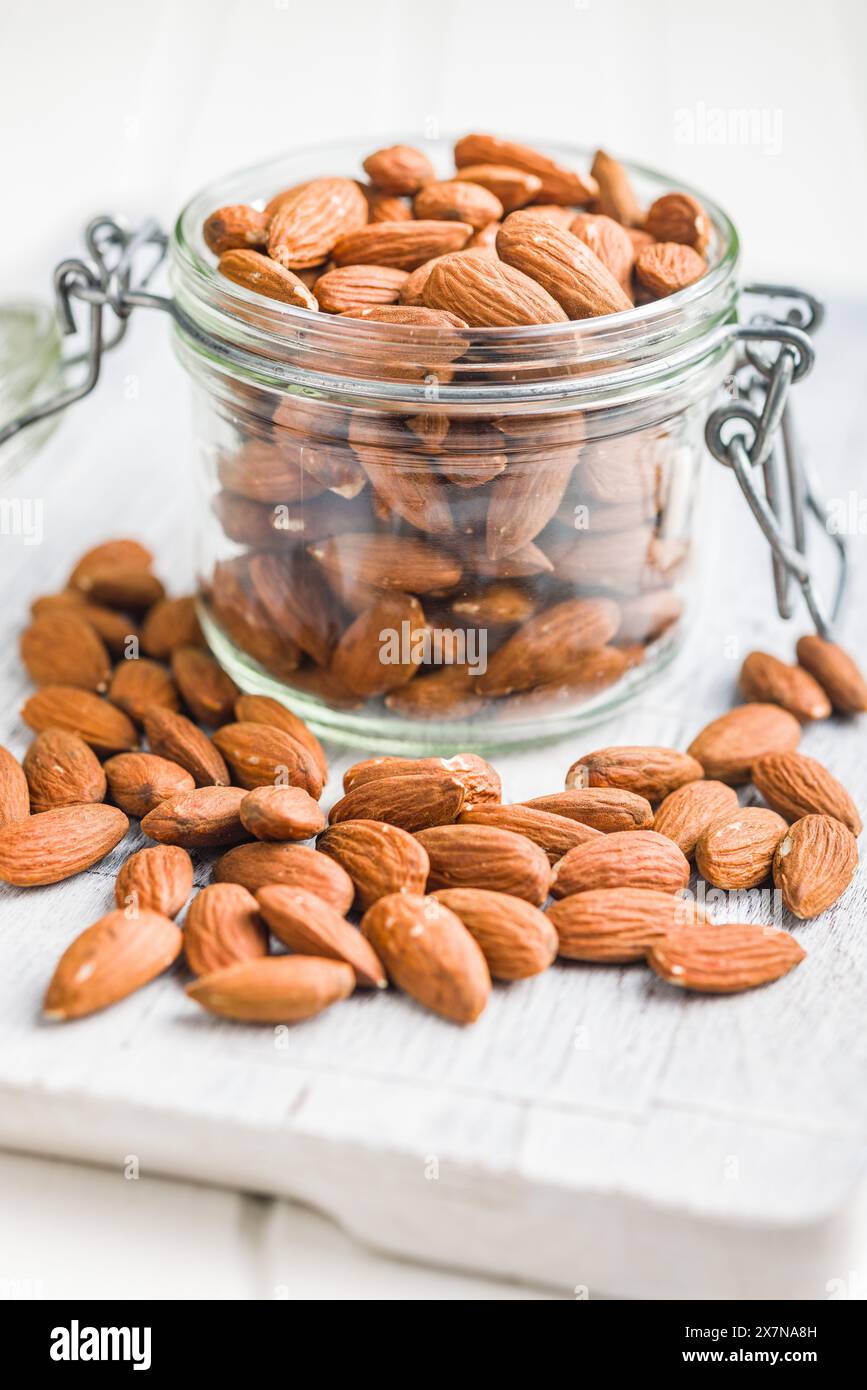 Peeled almond nuts in jar on a kitchen table. Stock Photo
