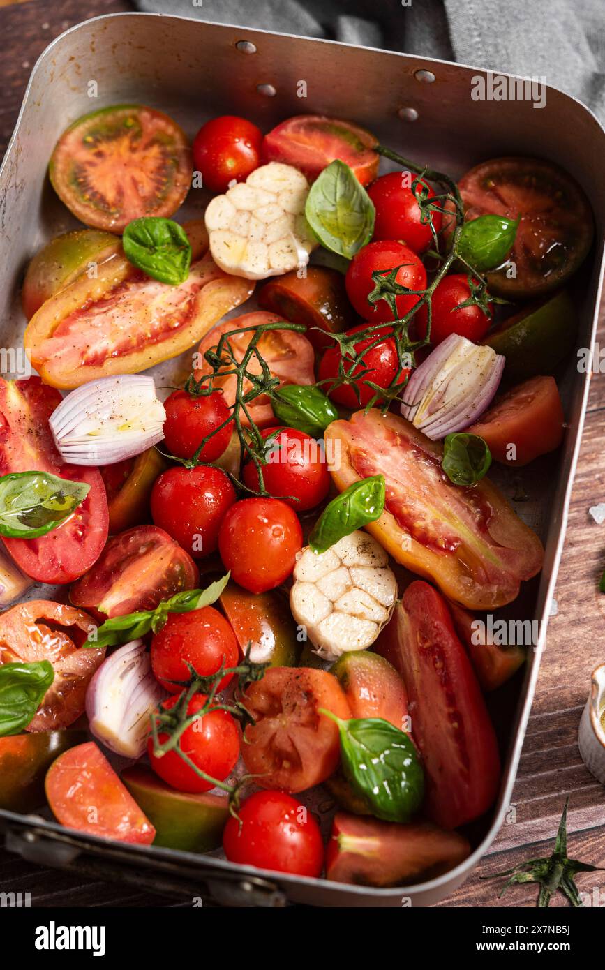 Fresh tomatoes, garlic, shallot, basil in baking pan Stock Photo