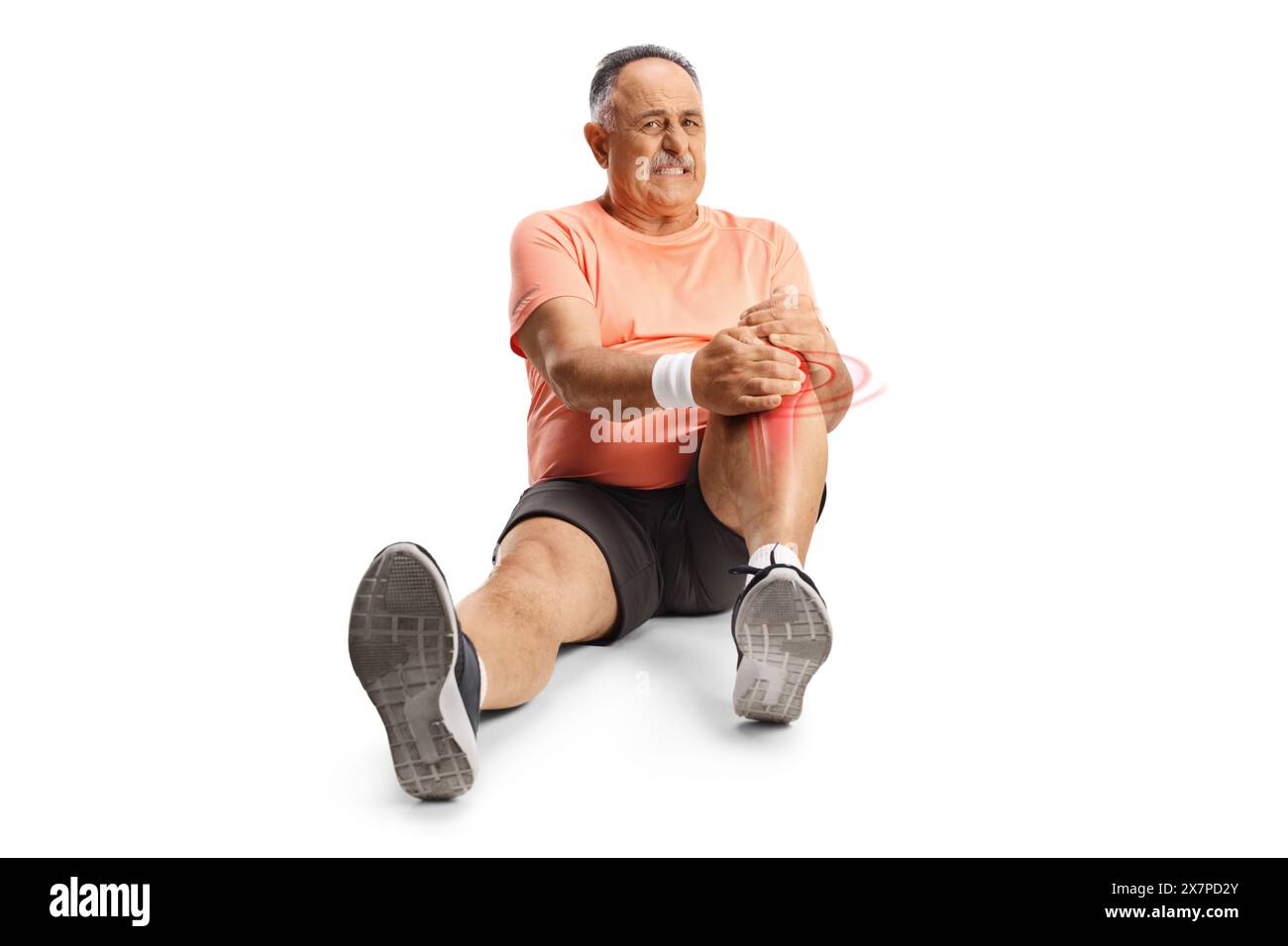Mature man in sport clothes sitting on the floor and holding his injured knee isolated on white background Stock Photo