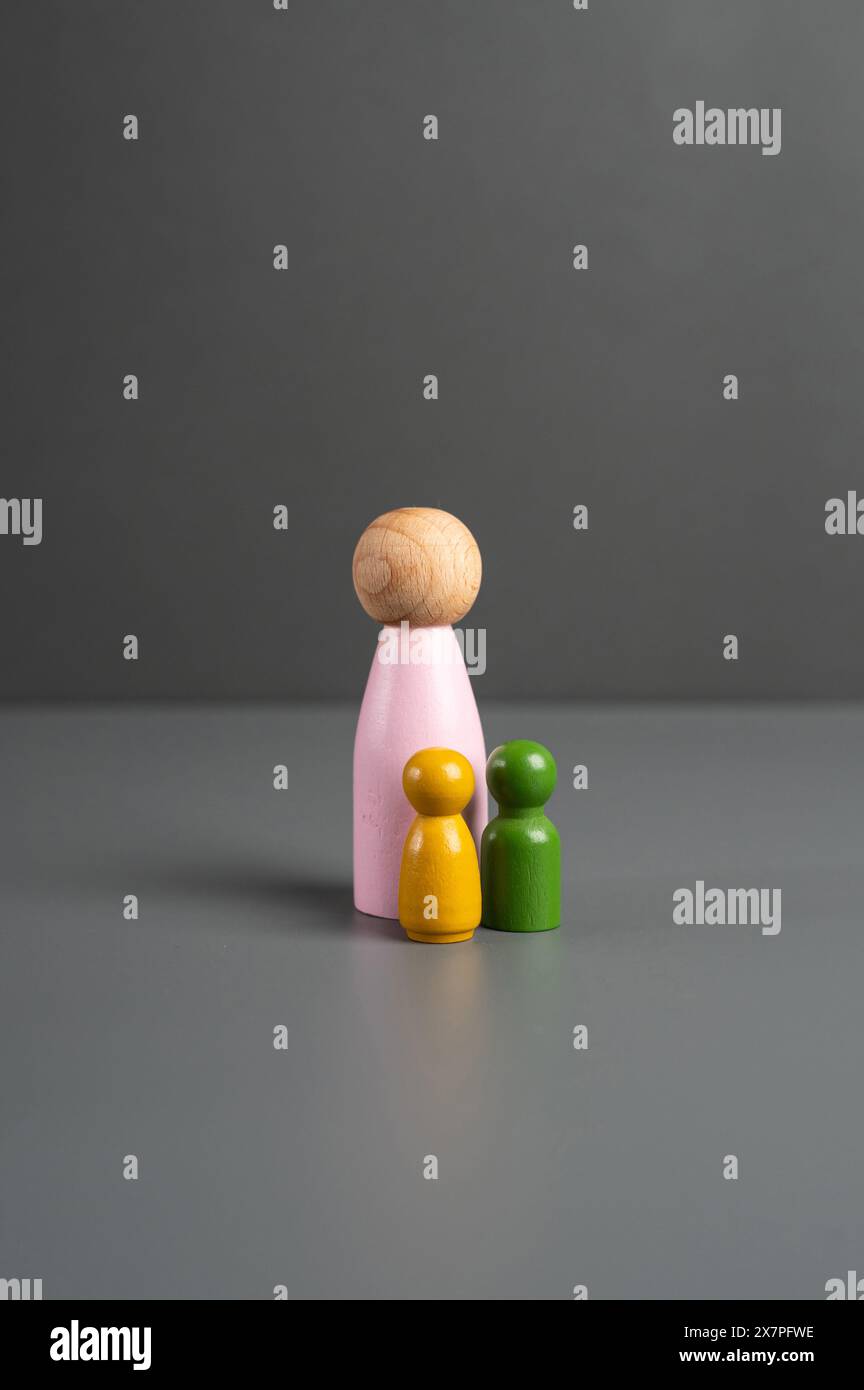 Figurine of mother and children. Social help. Motherhood and care, education and guardianship. Stock Photo