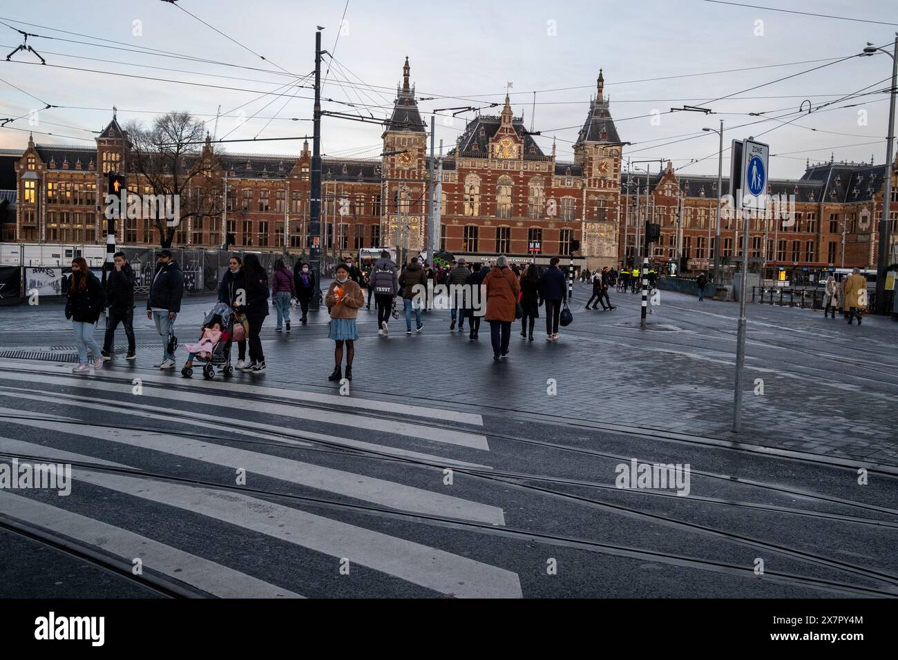 Travelling tourists in front of the monumental historic facade of the Central Station, officially named Amsterdam-Central in Amsterdam, capital of the Stock Photo