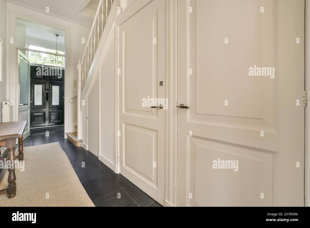 A spacious hallway featuring a classic black and white color scheme ...