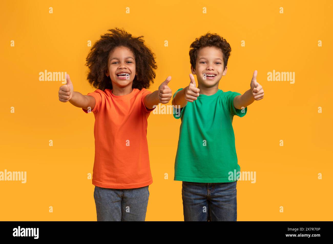 Two Children Giving Thumbs Up on an Orange Background Stock Photo - Alamy
