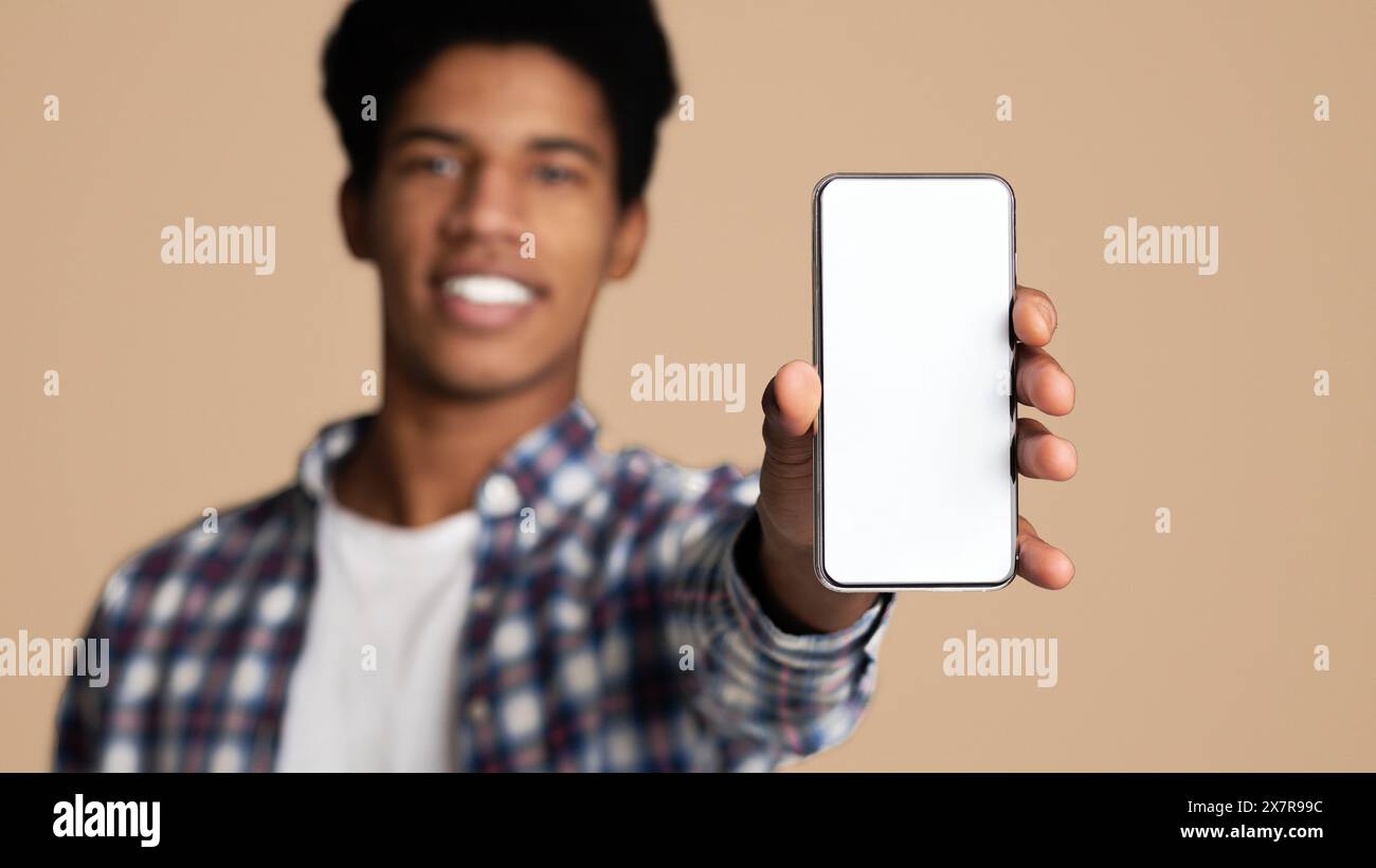 Black guy showing blank cellphone screen, closeup Stock Photo