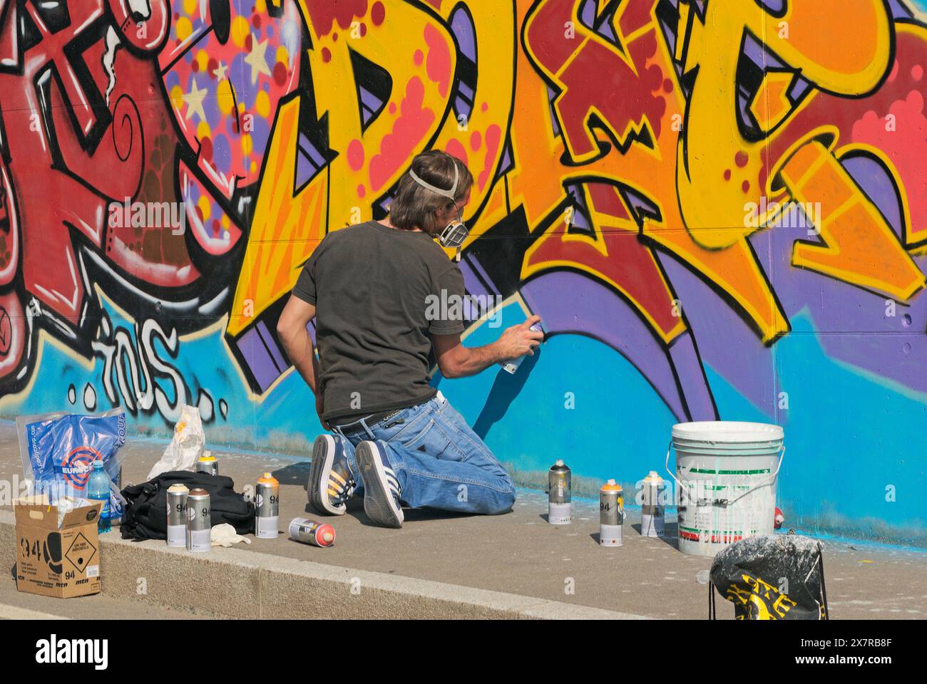 Male graffiti artist using spray for a large mural Stock Photo