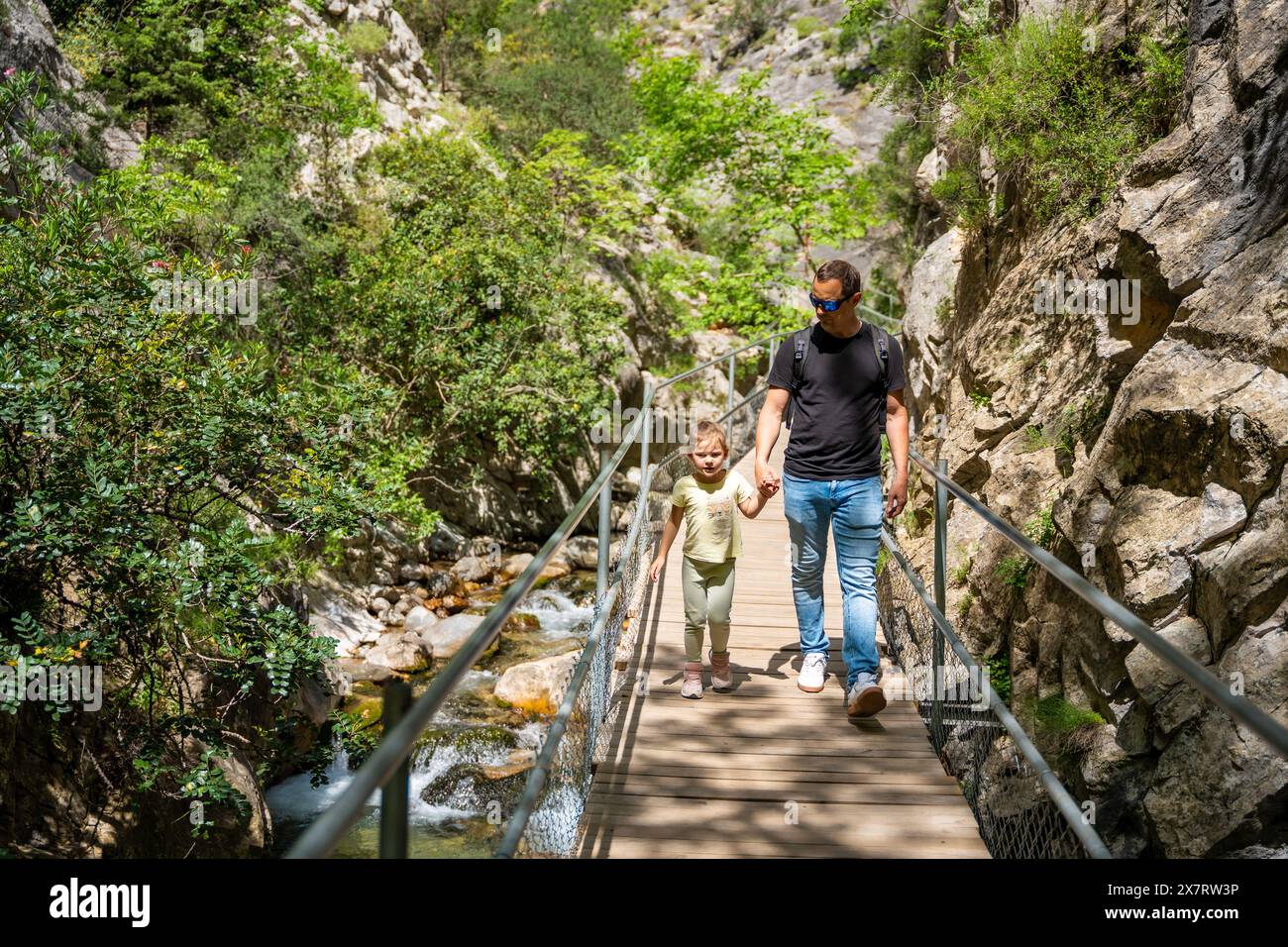 Father With Little Girl Hiking In Sapadere Canyon With Wooden Paths And father-with-little-girl-hiking-in-sapadere-canyon-with-wooden-paths-and