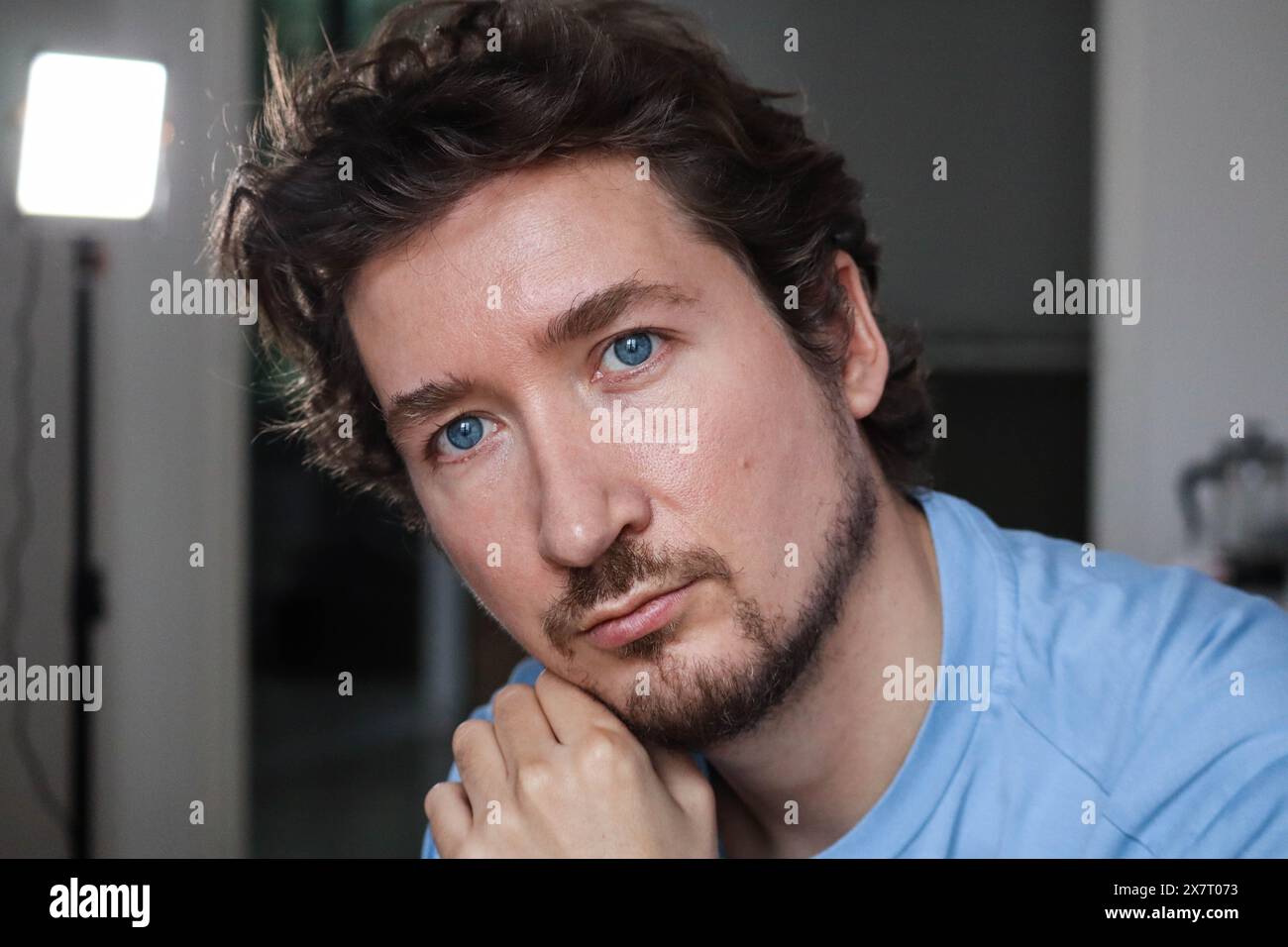 Handsome young man with blue eyes and curly wavy hair Stock Photo - Alamy