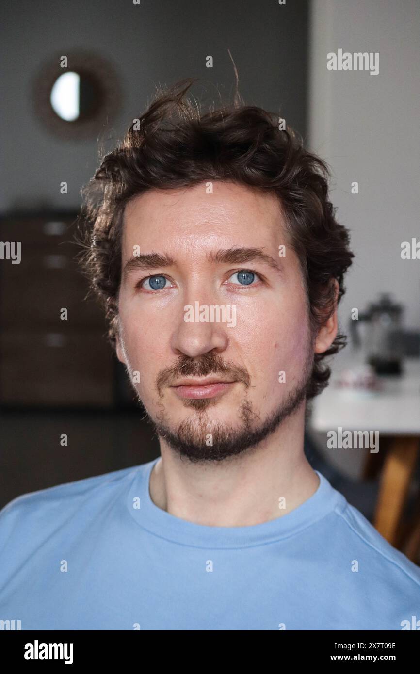 Handsome young man with blue eyes and curly wavy hair Stock Photo - Alamy