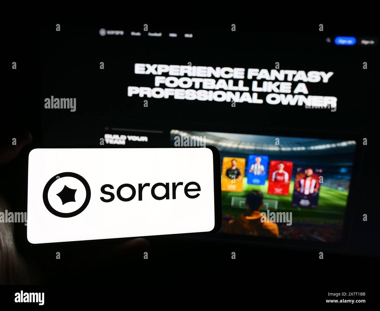 Person holding smartphone with logo of French crypto fantasy sport company Sorare SAS in front of website. Focus on phone display. Stock Photo