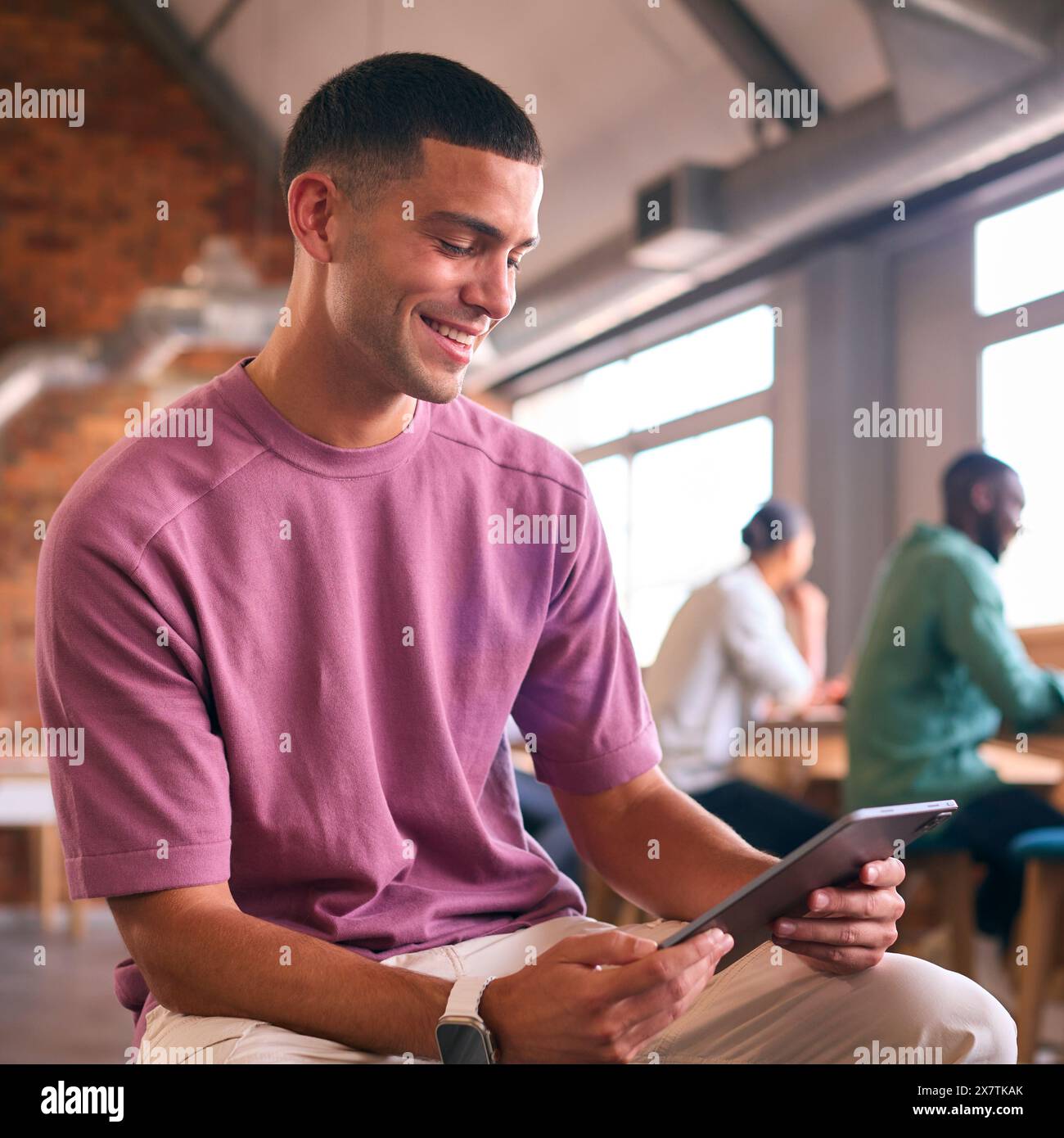 Young Businessman Using Digital Tablet Working In Modern Open Plan Office Stock Photo