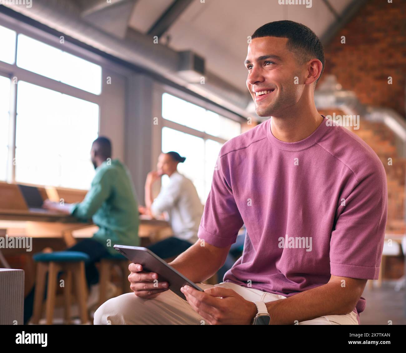 Young Businessman Using Digital Tablet Working In Modern Open Plan Office Stock Photo
