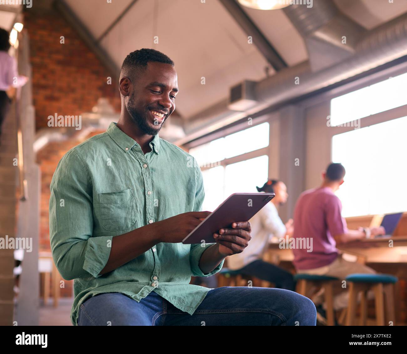 Businessman Using Digital Tablet Working In Modern Open Plan Office Stock Photo