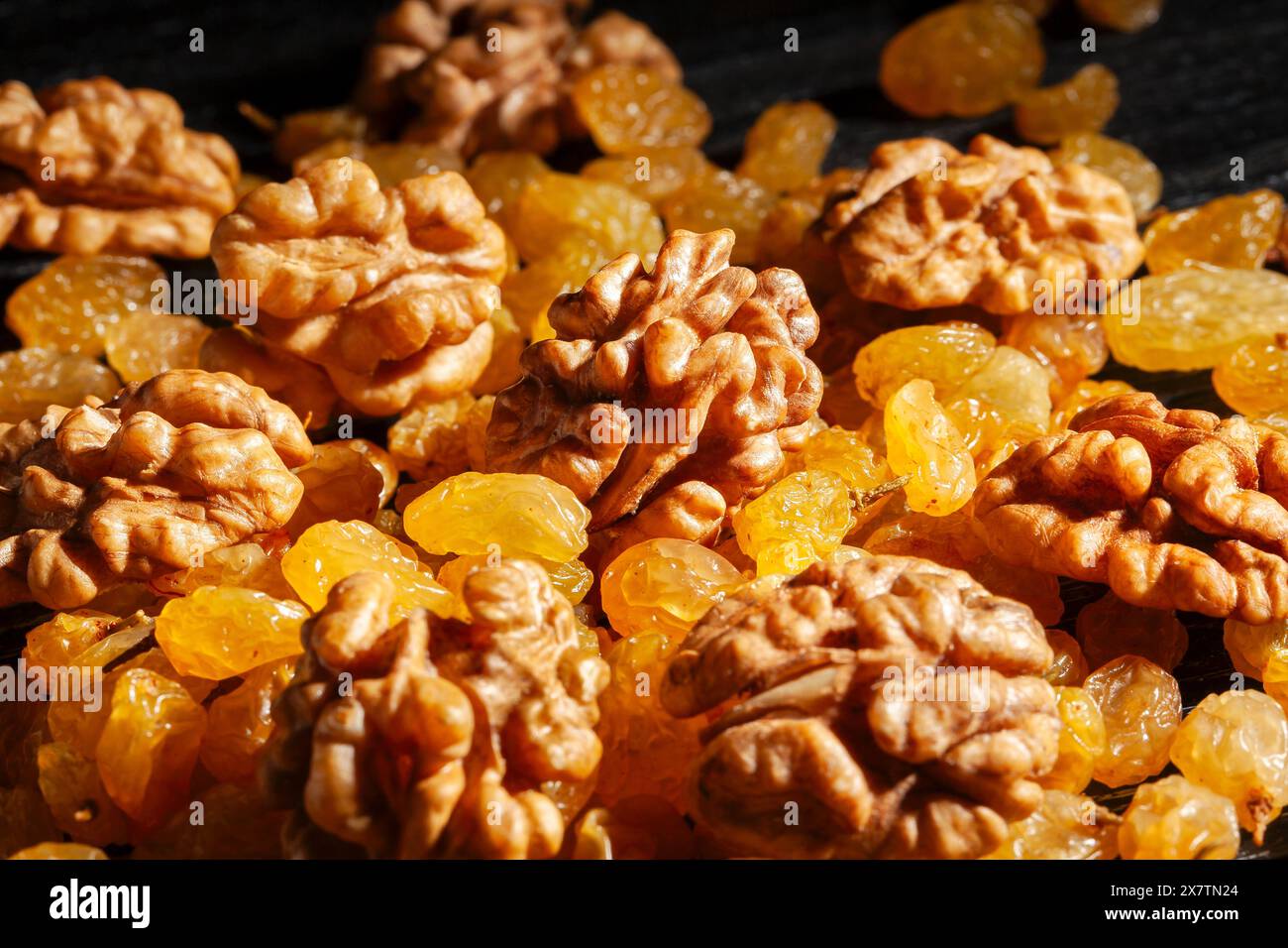 walnuts raisins on black wood background Stock Photo