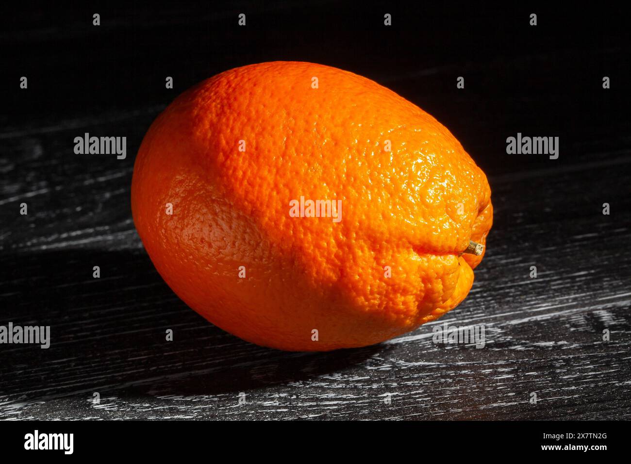 calabrian oval blond oranges on black wood background Stock Photo