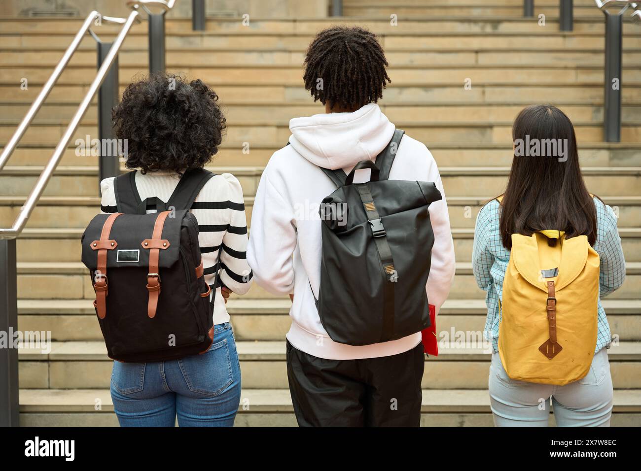 Three students showing backpacks going to University Stock Photo - Alamy