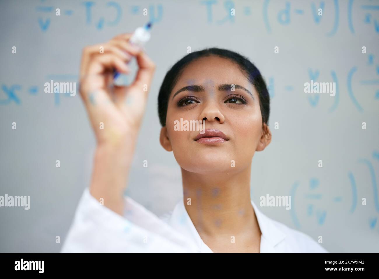 Hand, equation and science on glass with woman in studio on gray ...