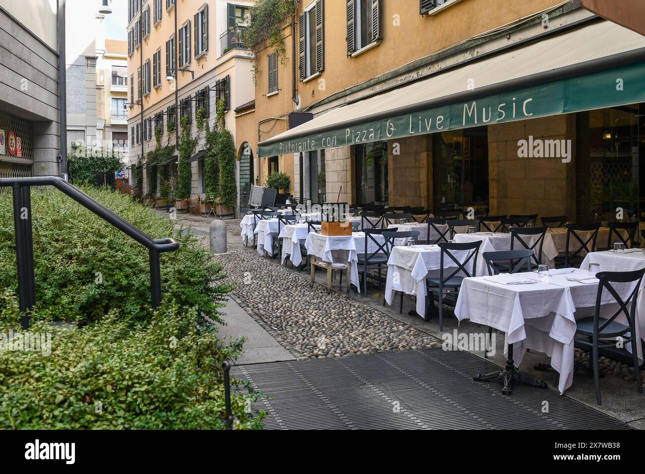 Exterior of a live music restaurant with tables on the sidewalk in an alley of the Brera district, Milan, Lombardy, Italy Stock Photo