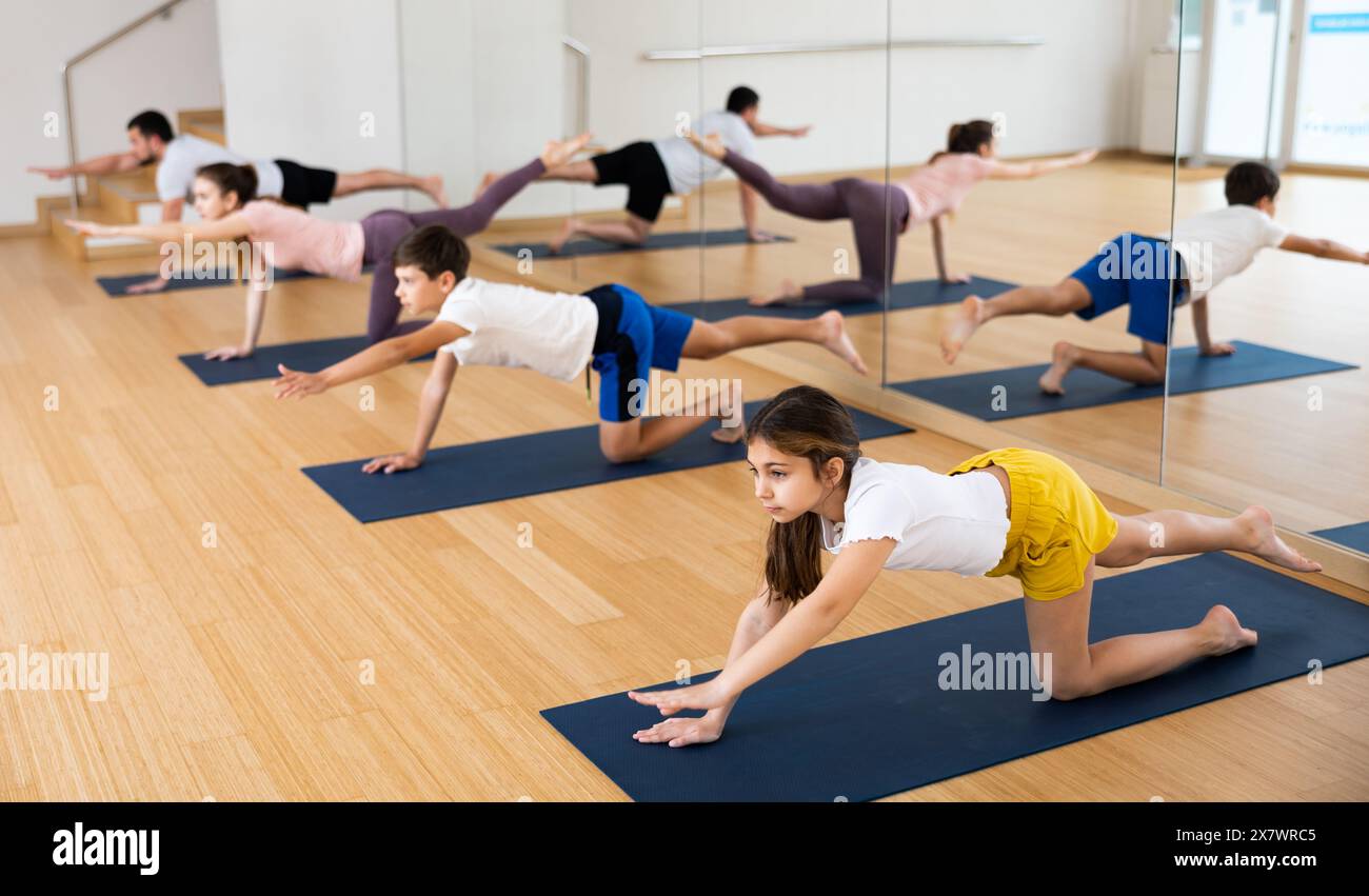Balancing Table Tween girl performing Balancing Table pose during family yoga class ...
