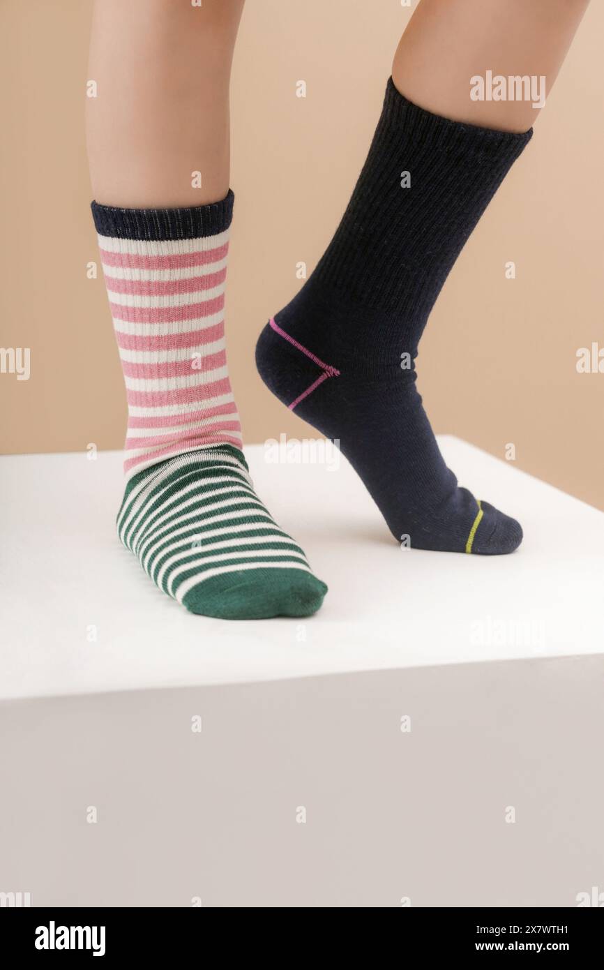 Kid wears different pair of socks. Child foots in mismatched socks