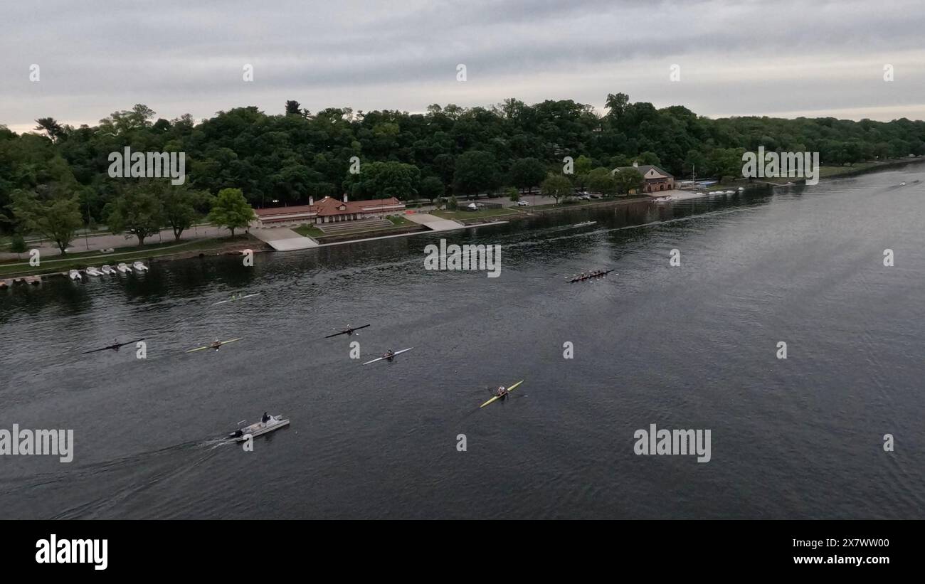 Rowers head past the Temple and St. Joseph's boathouses along the Schuylkill River in Philadelphia. Stock Photo