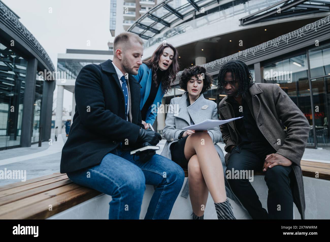 Multiracial business team collaborating on a project outdoors. Stock Photo