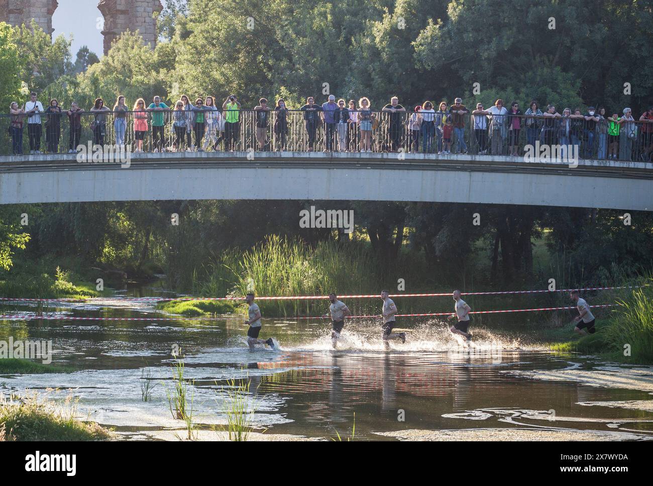 Merida, Spain - May 18th, 2024: FarinatoRace Merida 2024, Participants crossing the Albarregas river Stock Photo