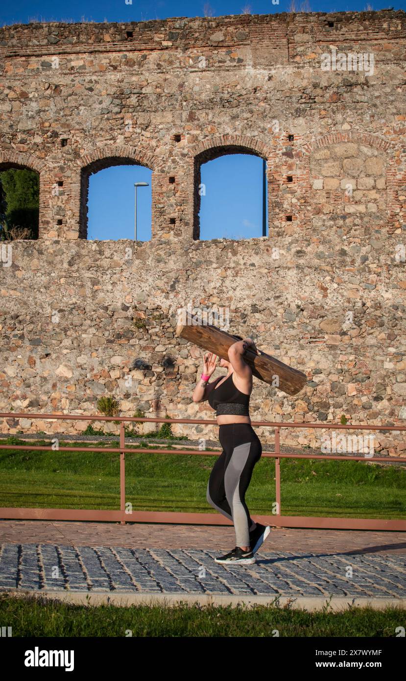 Merida, Spain - May 18th, 2024: FarinatoRace Merida 2024. Woman carrying a heavy log on his shoulder Stock Photo