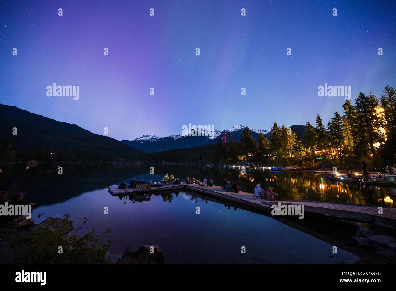 Crowds of people watch the Northern Lights shine brightly over Green Lake, near Whistler BC, Canada.  A solar storm that evening caused an unusually b Stock Photo