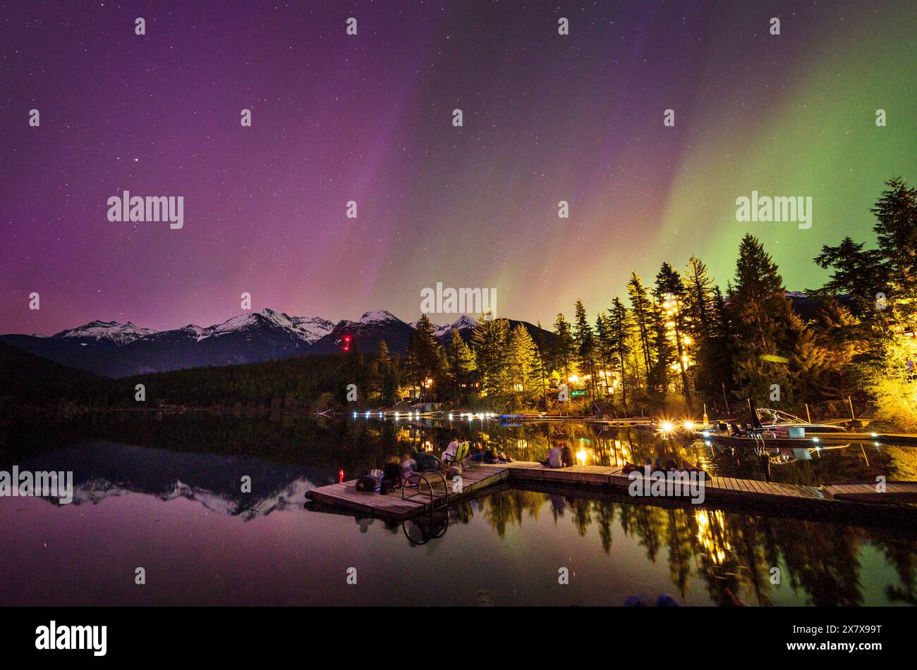 Crowds of people watch the Northern Lights shine brightly over Green Lake, near Whistler BC, Canada.  A solar storm that evening caused an unusually b Stock Photo