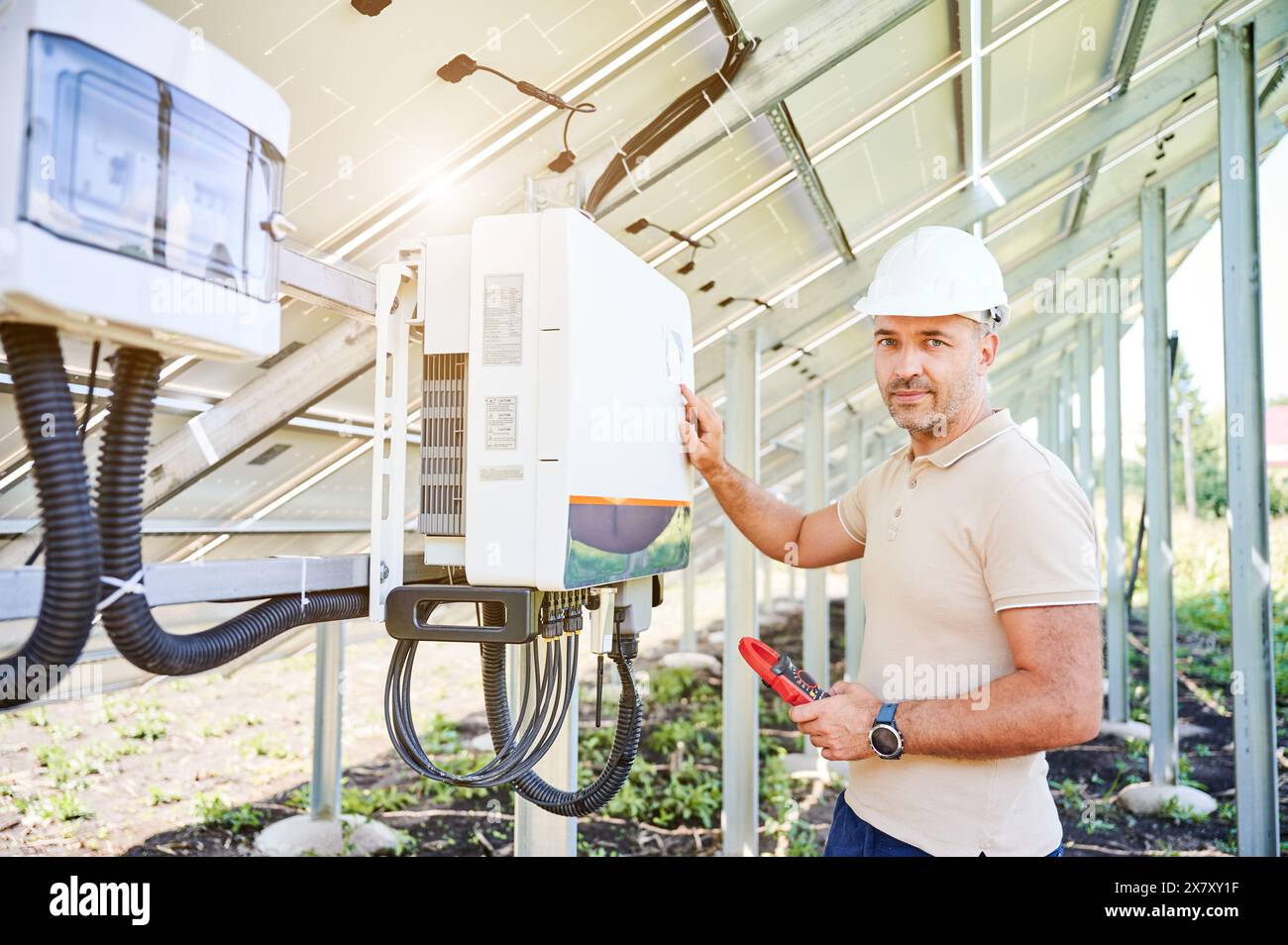 Professional worker checking voltage on solar inverter. Male using ...