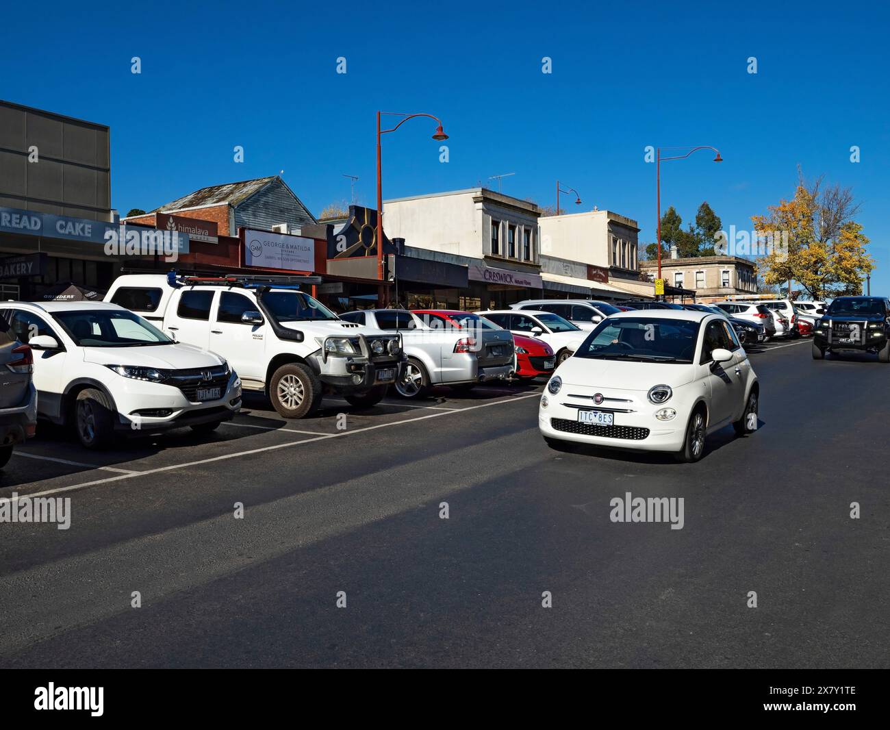 Daylesford Australia /  A small Fiat car travels along Vincent Street  in Daylesford on a sunny Autumn afternoon. Stock Photo