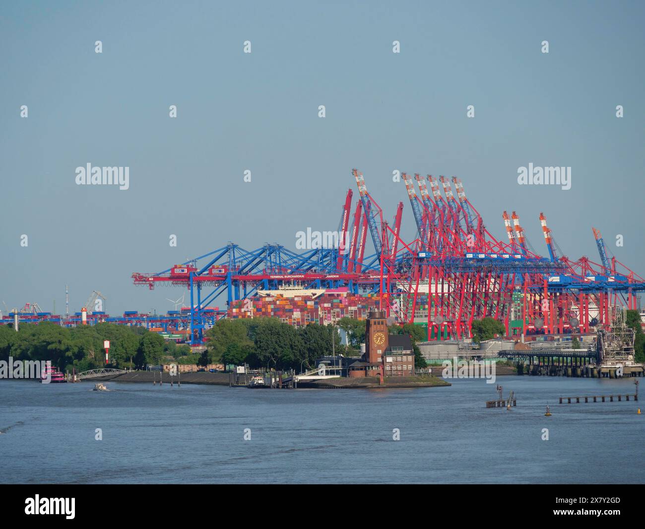 Container cranes at the harbour with a river and buildings in the ...