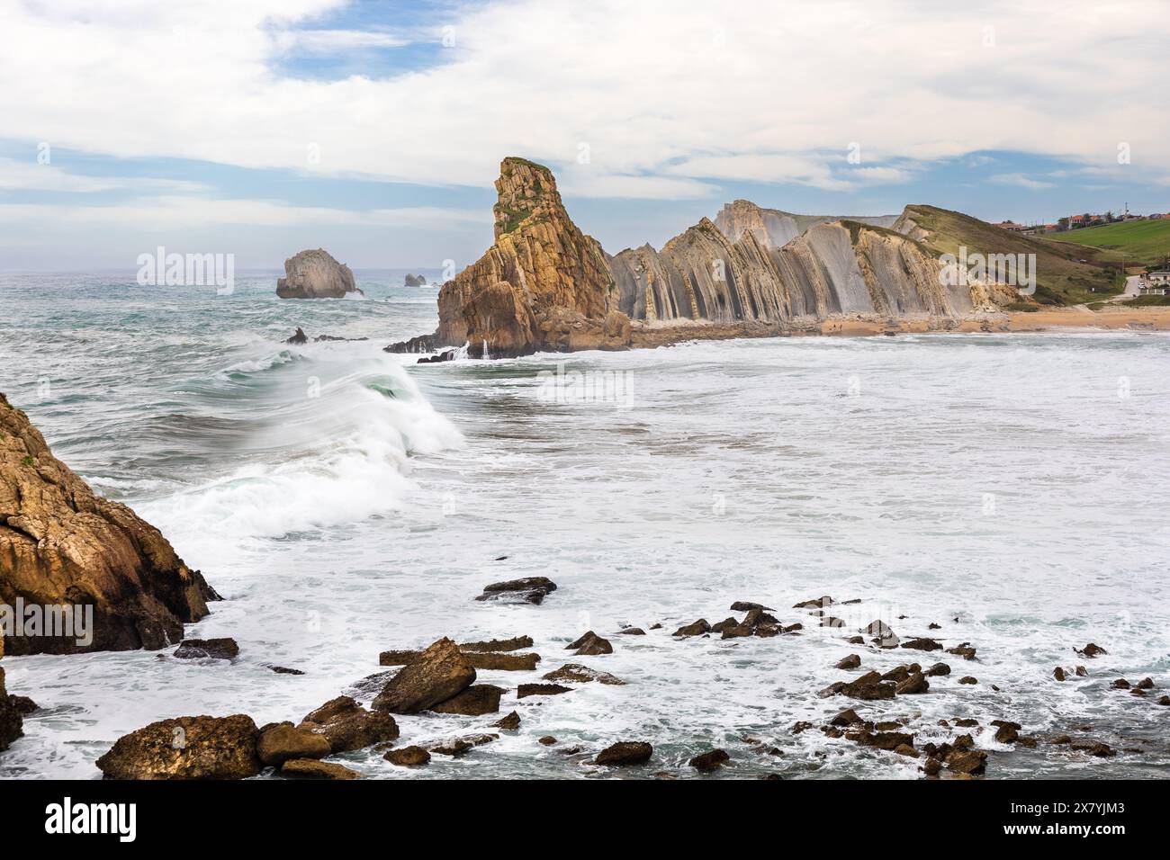 Massive coastal rocks of unusual shape and the stormy Atlantic Ocean. Costa Quebrada Geopark, Cantabria, Spain. Stock Photo