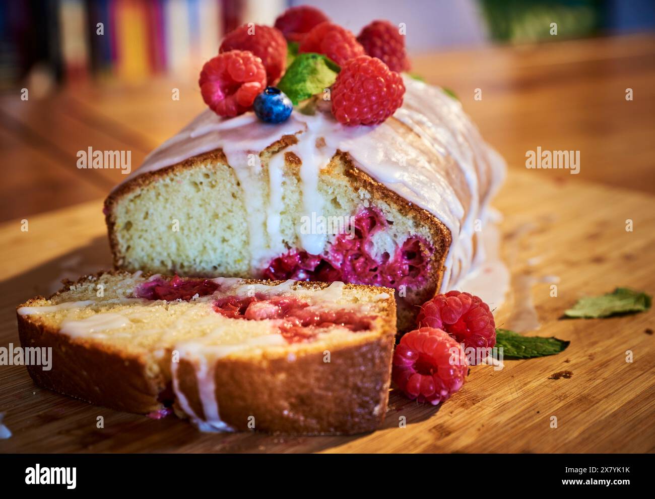 Delicious raspberry summer cake on a wooden table. Enticing soft baked plumcake or plum cake with raspberries. Colourful tempting baked fruitcake Stock Photo