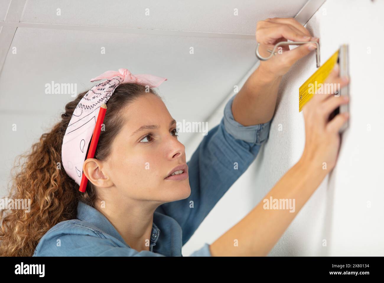 woman holding a meter measuring dimensions on wall Stock Photo - Alamy