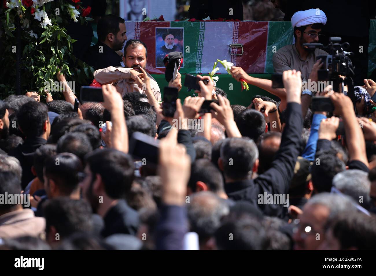 Tehran, Iran. May 22, 2024, Tehran, Iran: Iranians mourners follow a truck carrying coffins of the late President Ebrahim Raisi and his companions, who were killed in a helicopter crash in a mountainous region of the country's northwest, during a funeral ceremony for them in Tehran. Credit: ZUMA Press, Inc./Alamy Live News Stock Photo