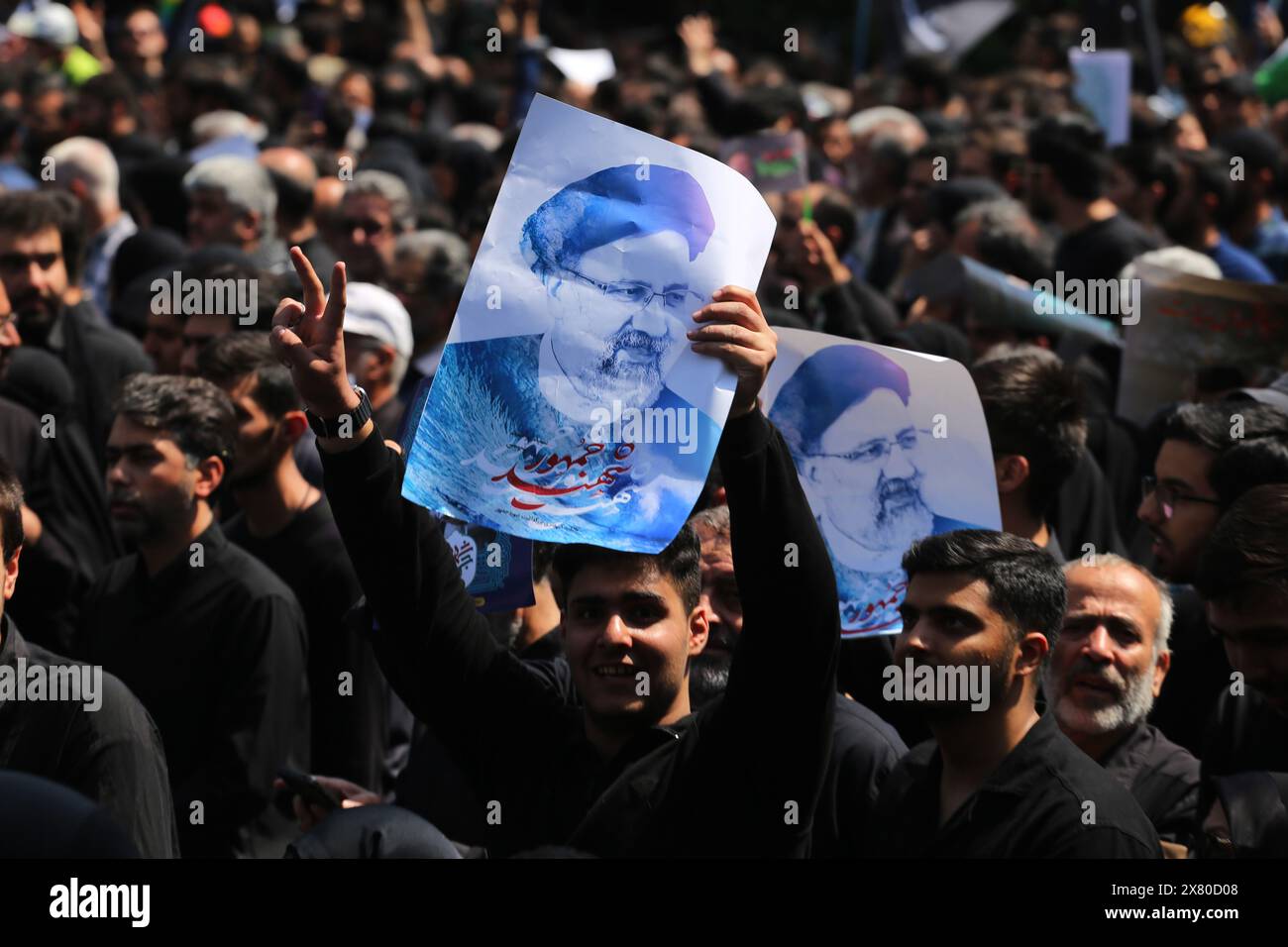 Tehran, Iran. May 22, 2024, Tehran, Iran: An Iranian man holds up a poster during a funeral ceremony for the late President Ebrahim Raisi and his companions who were killed during a helicopter crash on Sunday in a mountainous region of the country's northwest, in Tehran. Credit: ZUMA Press, Inc./Alamy Live News Stock Photo