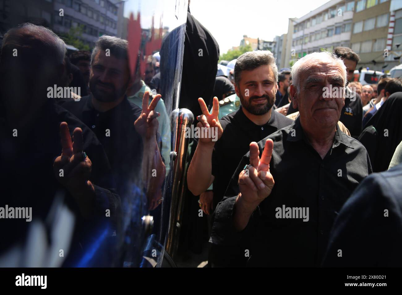 Tehran, Iran. Tehran, Iran. 22nd May, 2024. Two Iranian men show victory signs during a funeral ceremony for the late President Ebrahim Raisi and his companions, who were killed during a helicopter crash in a mountainous region of the country's northwest in Tehran. Credit: ZUMA Press, Inc./Alamy Live News Stock Photo