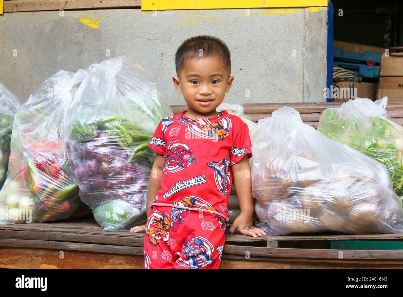 A young Filipino boy play with the camera by posing & asking for more pictures, asian child in pyjama, cute pinoy mischievous baby face, Philippines Stock Photo