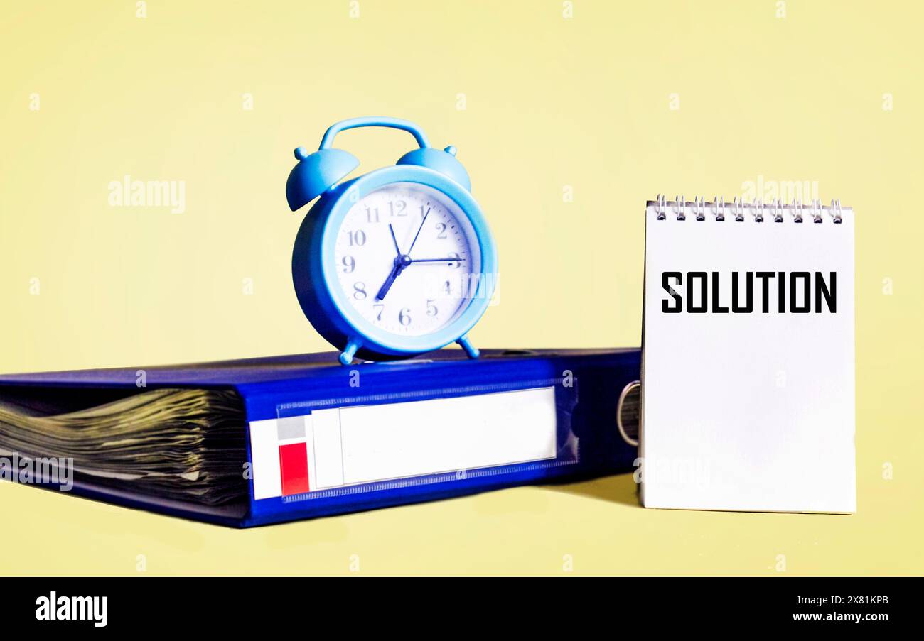 The word solution written on a notepad on a yellow background Stock Photo