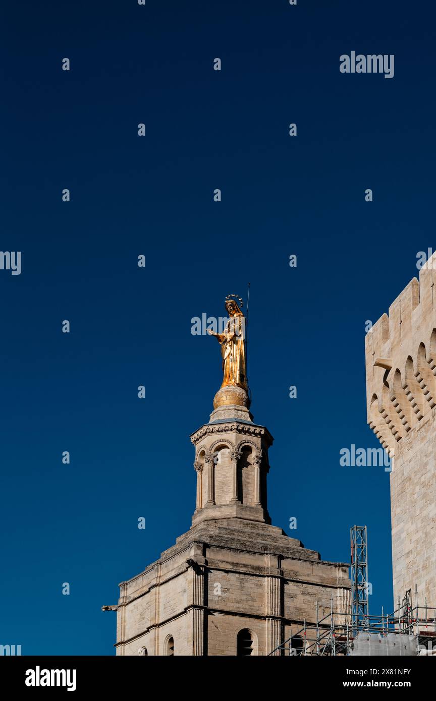 Golden statue of virgin mary shines brightly in Avignon under a vast, clear deep blue sky. Stock Photo