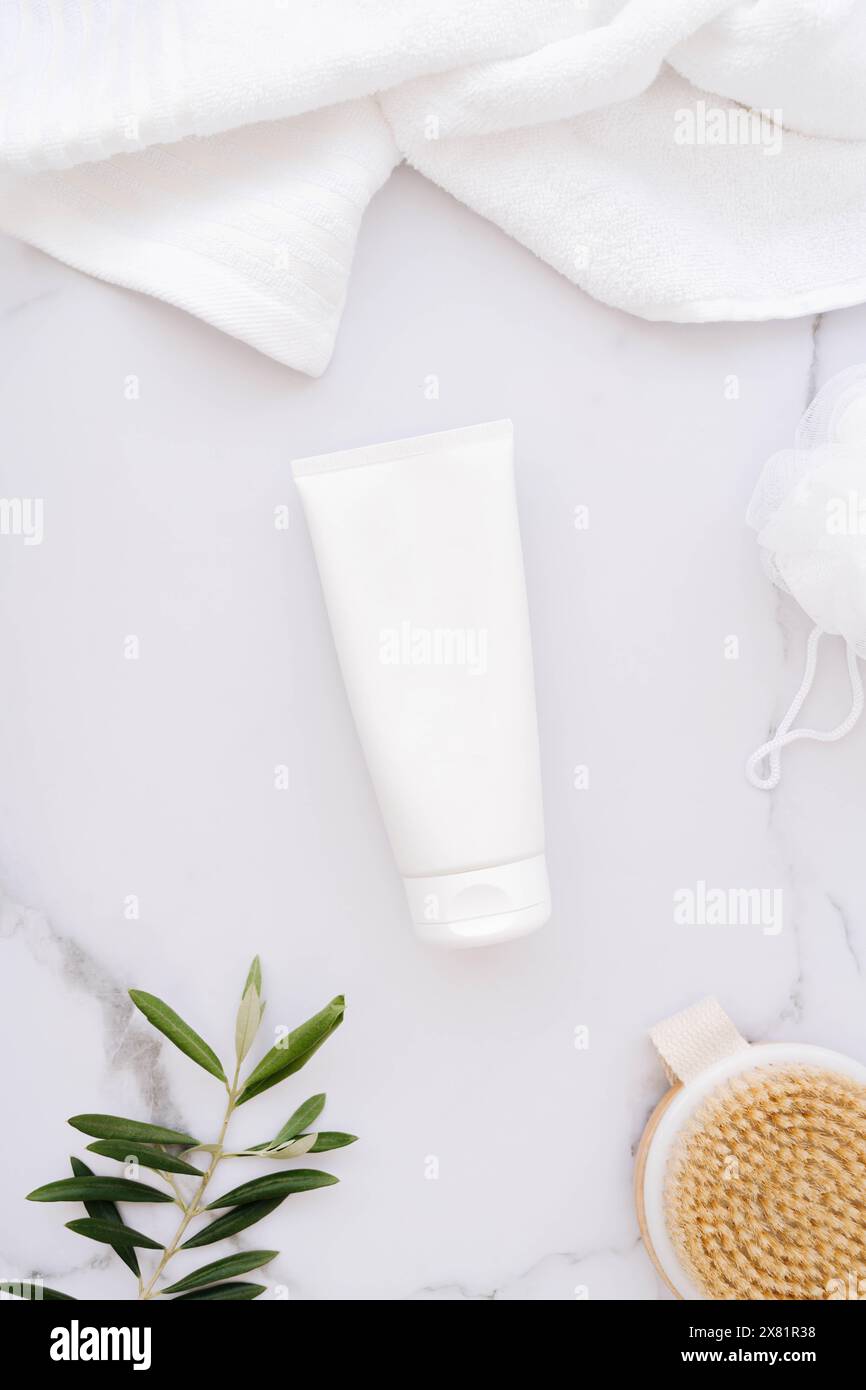 Flat lay of white plastic bottle without label, wooden brush, sponge ...