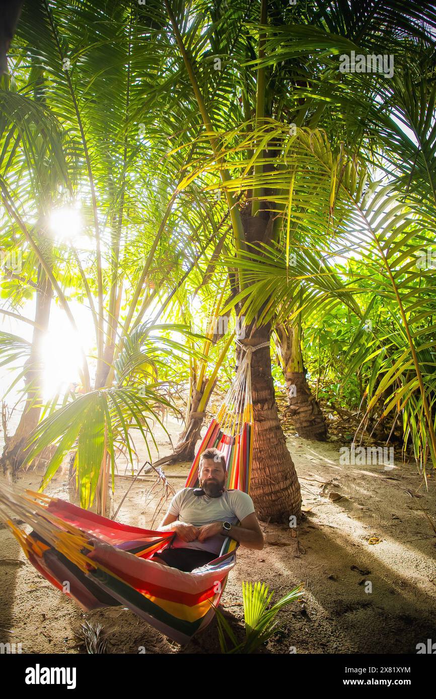 man working on laptop on exotic beach Stock Photo