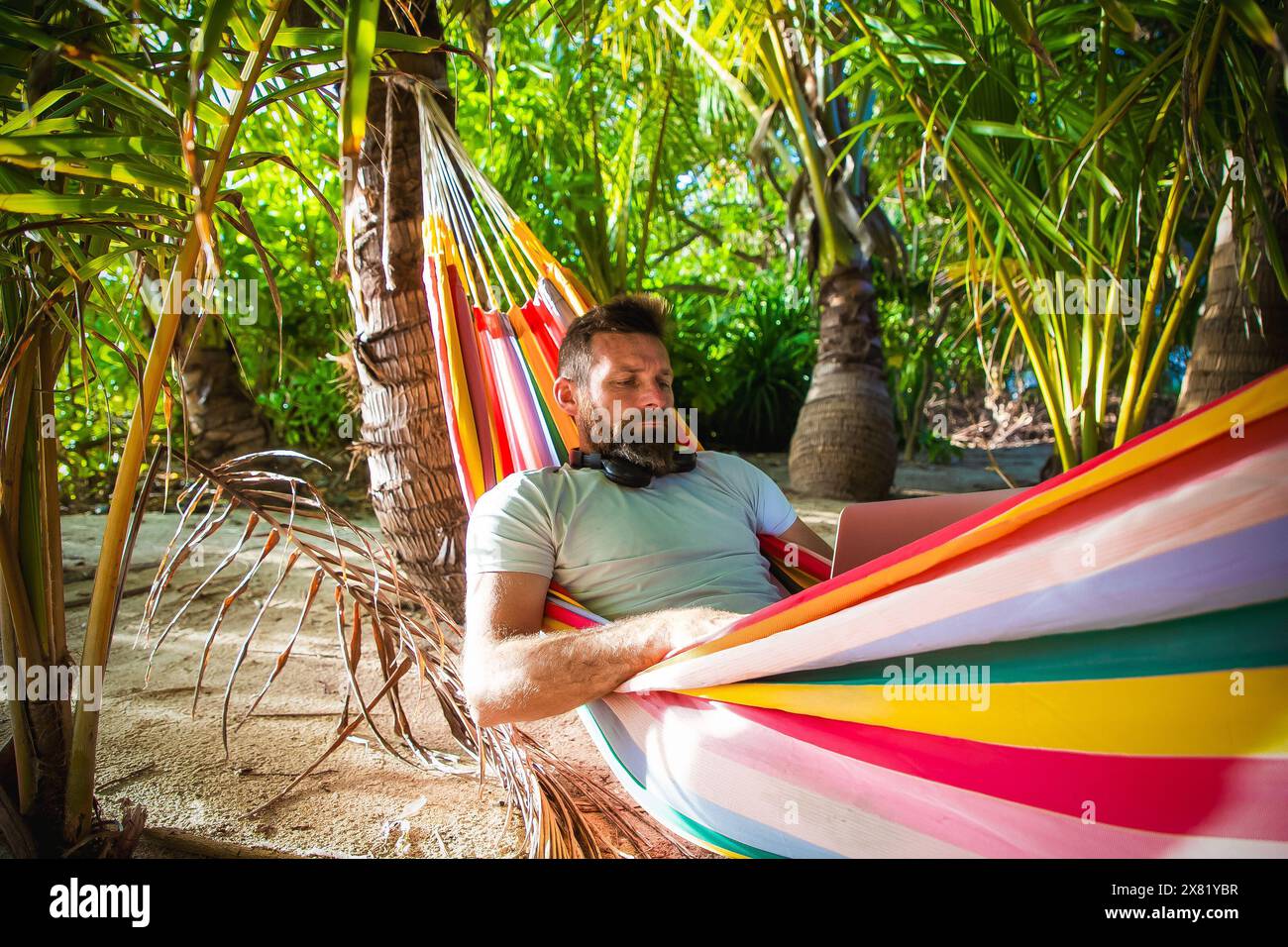man working on laptop on exotic beach Stock Photo