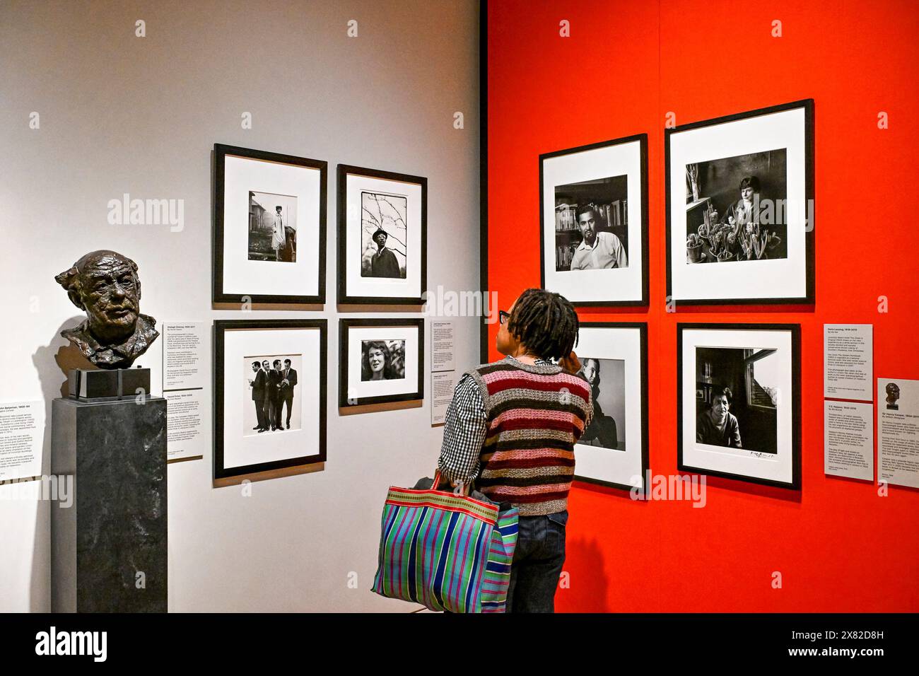 Woman looking at black and white photograph, National Portrait Gallery, London, England, UK. Stock Photo
