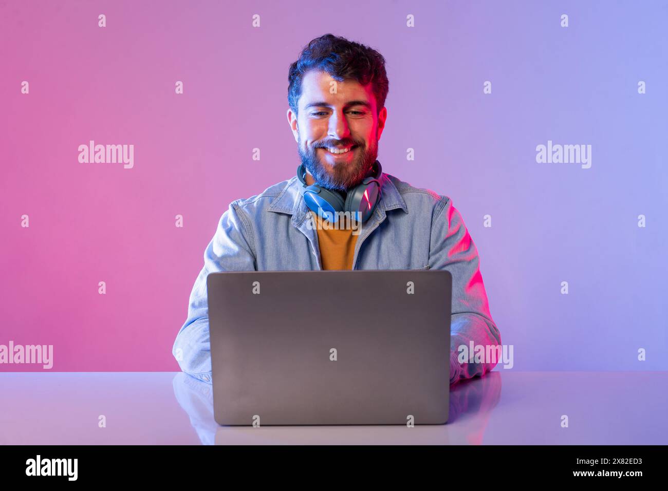 Man Sitting at Table Using Laptop Computer Stock Photo