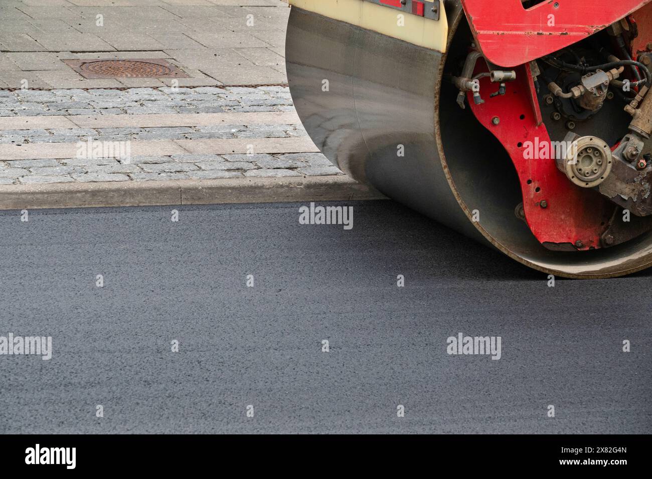 Close up of road construction asphalt roller machine at work. Heavy Vibration roller compactor at pavement works for road repairing. Stock Photo