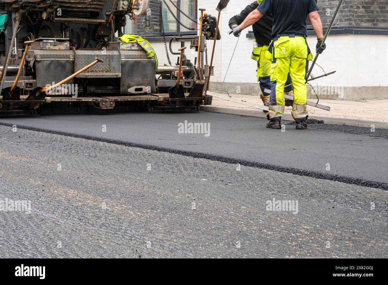 Repair of asphalt road surface - old layer removed and a coating Industrial pavement truck laying new fresh asphalt on construction site. Stock Photo